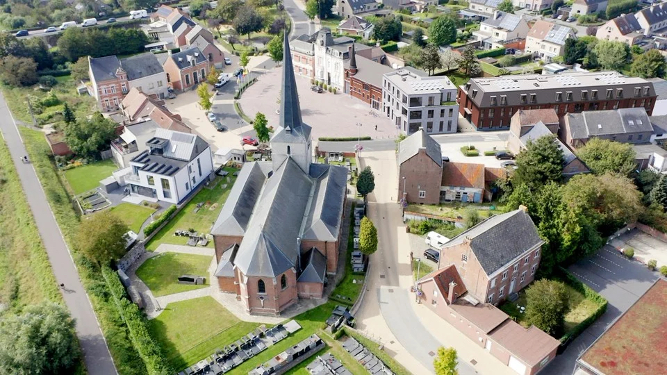 Heffena ligt op het dorpsplein, hier rechts van de Sint-Amanduskerk.